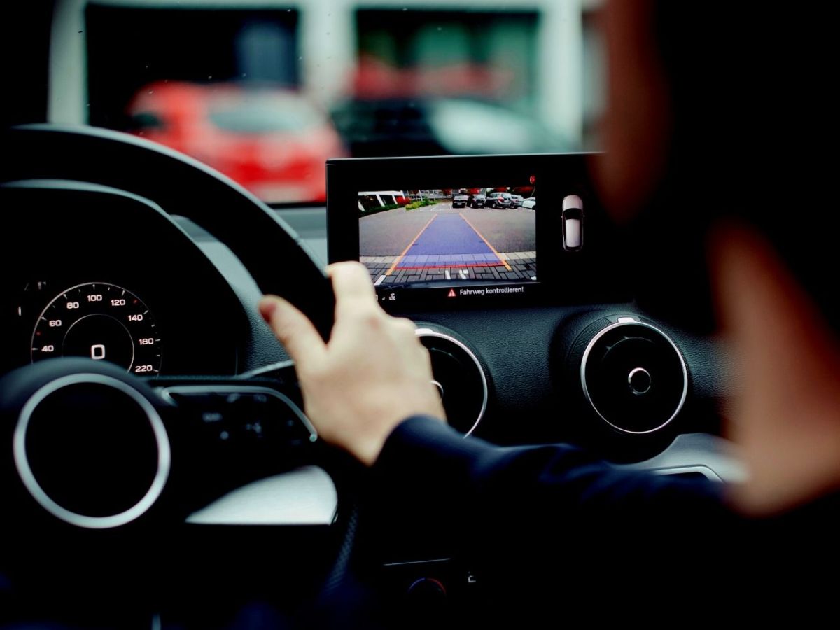 Mann sitzt in einem Auto mit kabelloser Rückfahrkamera