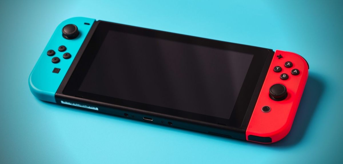 Eine Nintendo Switch OLED auf blauem Untergrund.