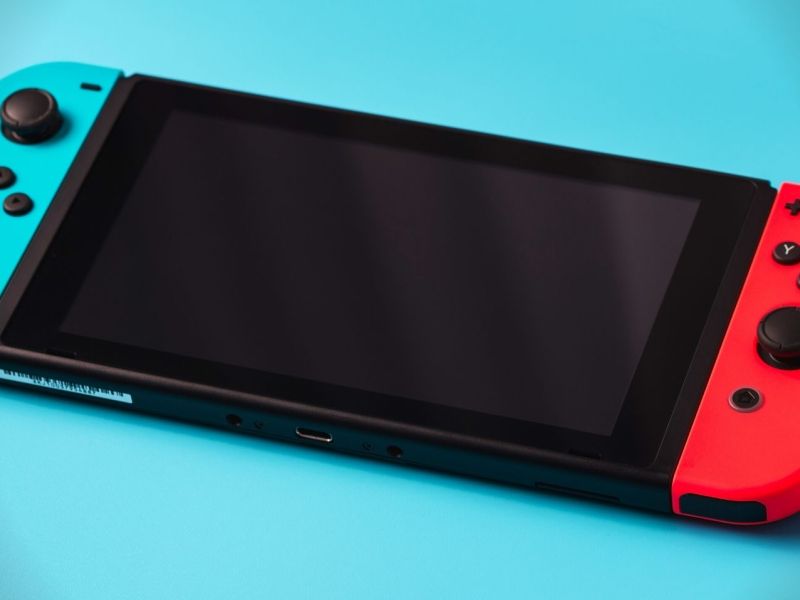 Eine Nintendo Switch OLED auf blauem Untergrund.