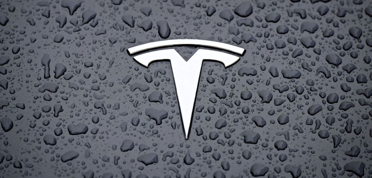 Tesla-Logo auf einer feuchten Oberfläche.