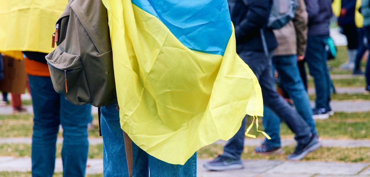Junge trägt Ukraine Flagge als Cape