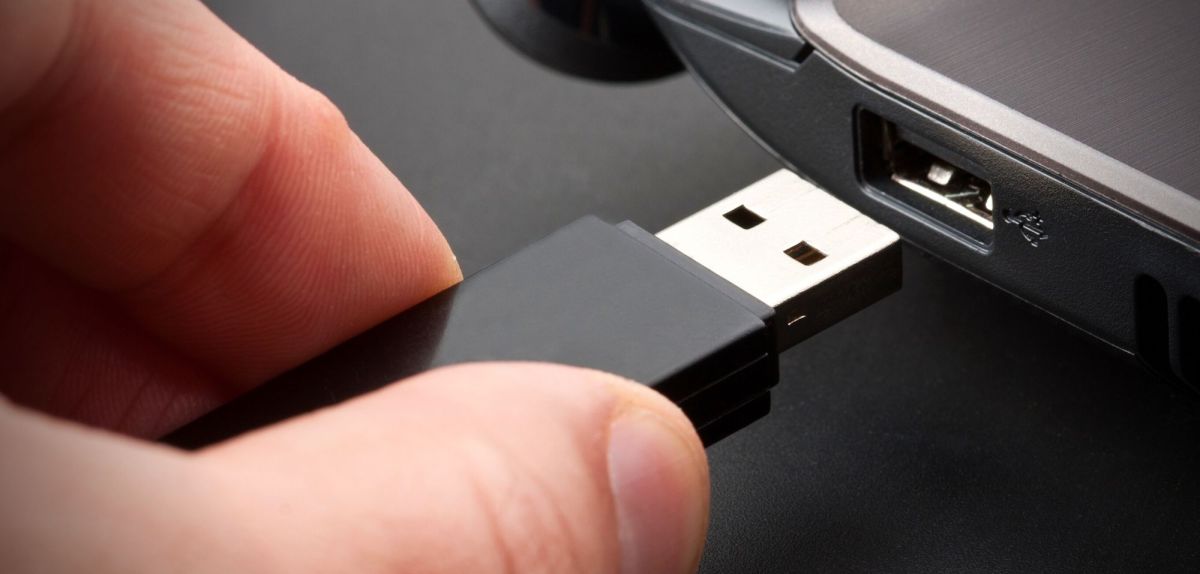 Person will USB-Stick in PC schieben