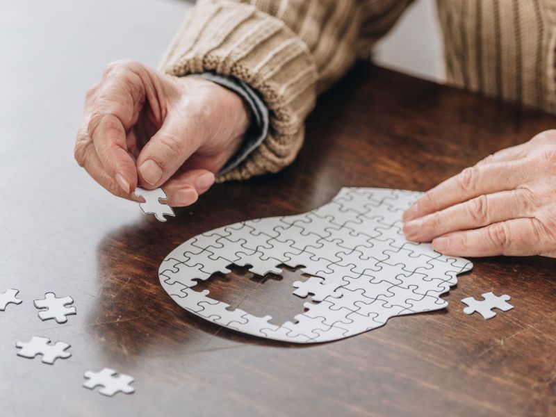Alte Frau puzzelt als Symbolbild für Demenz