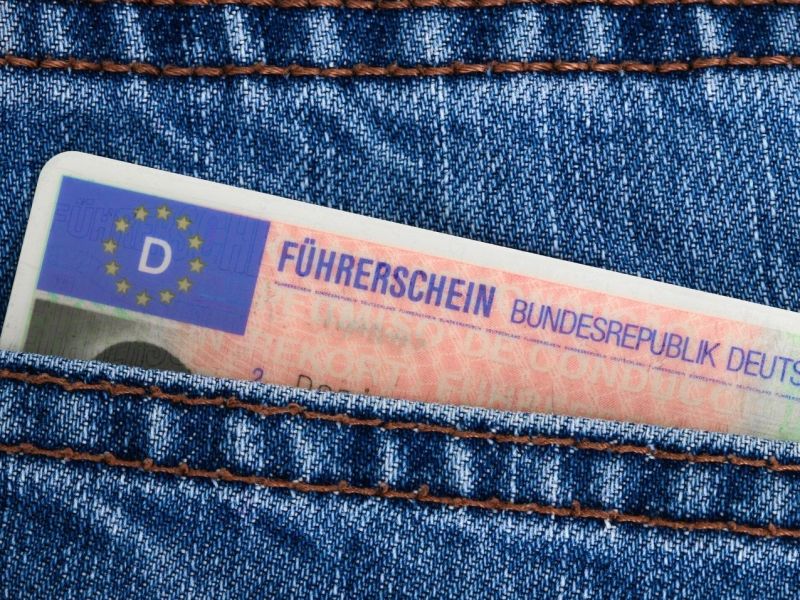 Führerschein ragt aus einer Hosentasche.