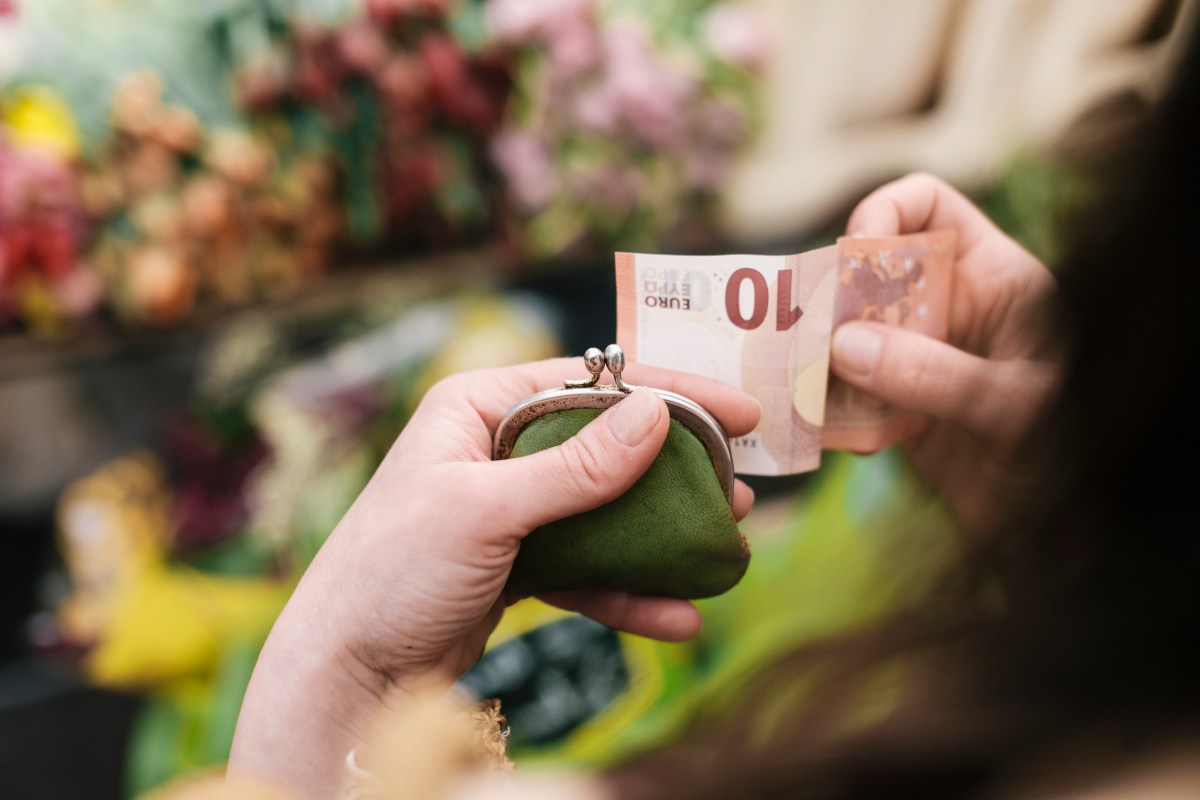 Eine Frau zieht einen 10-Euro-Schein aus dem Portemonnaie.