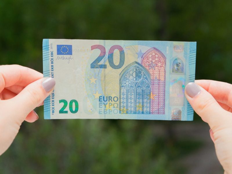 Frau hält einen 20-Euro-Schein in der Hand.