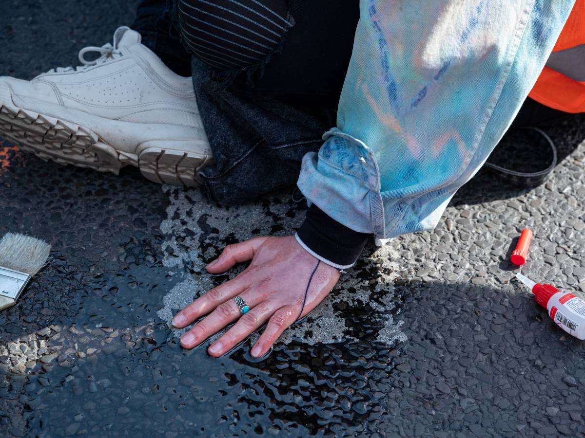 Hand klebt auf dem Asphalt.