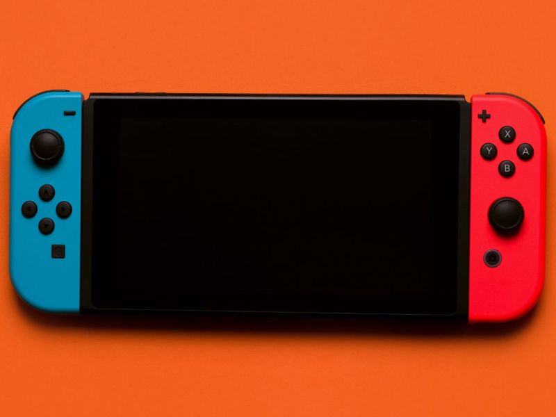 Eine Nintendo Switch auf orangenem Untergrund.