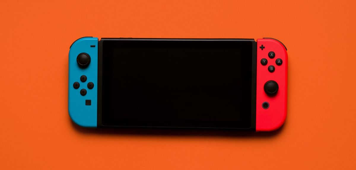 Eine Nintendo Switch auf orangenem Untergrund.