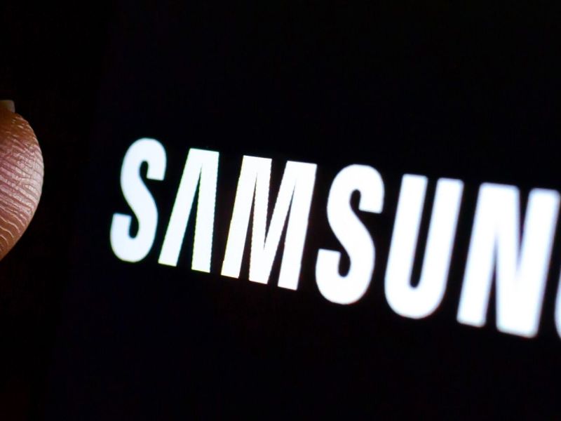 Finger über einem Samsung-Logo auf schwarzem Grund