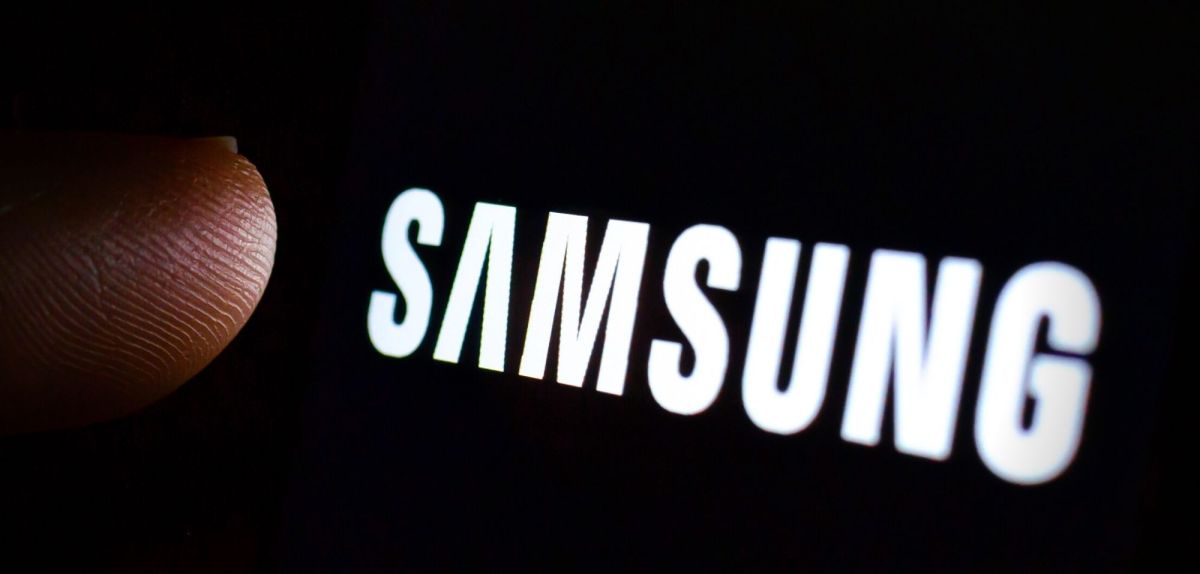 Finger über einem Samsung-Logo auf schwarzem Grund