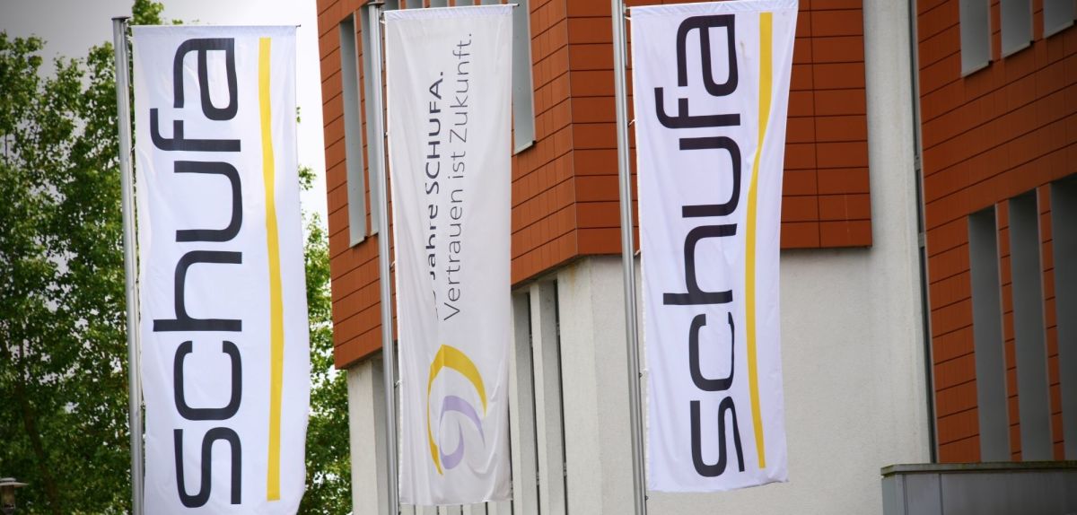 Schufa-Logo vor Gebäude.