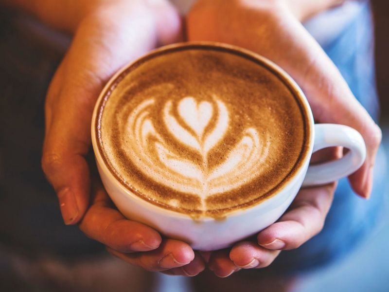 Person hält eine Tasse Kaffee