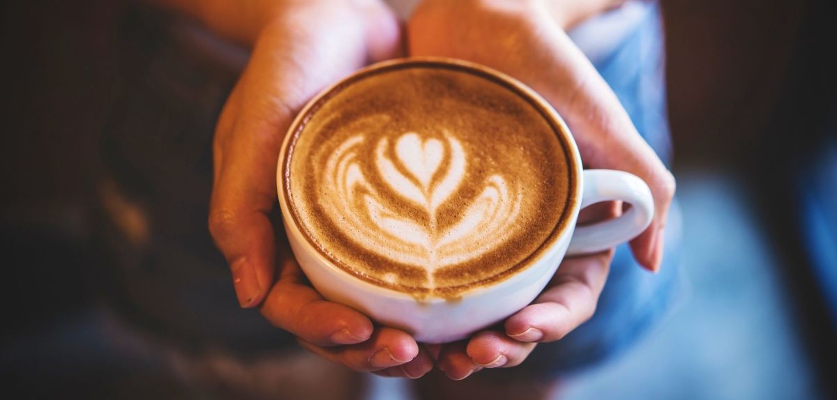 Person hält eine Tasse Kaffee