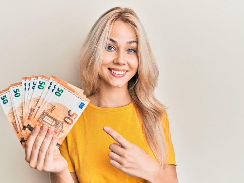 Frau hält hunderte Euro in der Hand