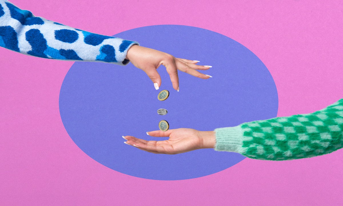 Frauen Hand lässt Münzen in eine andere Hand fallen.