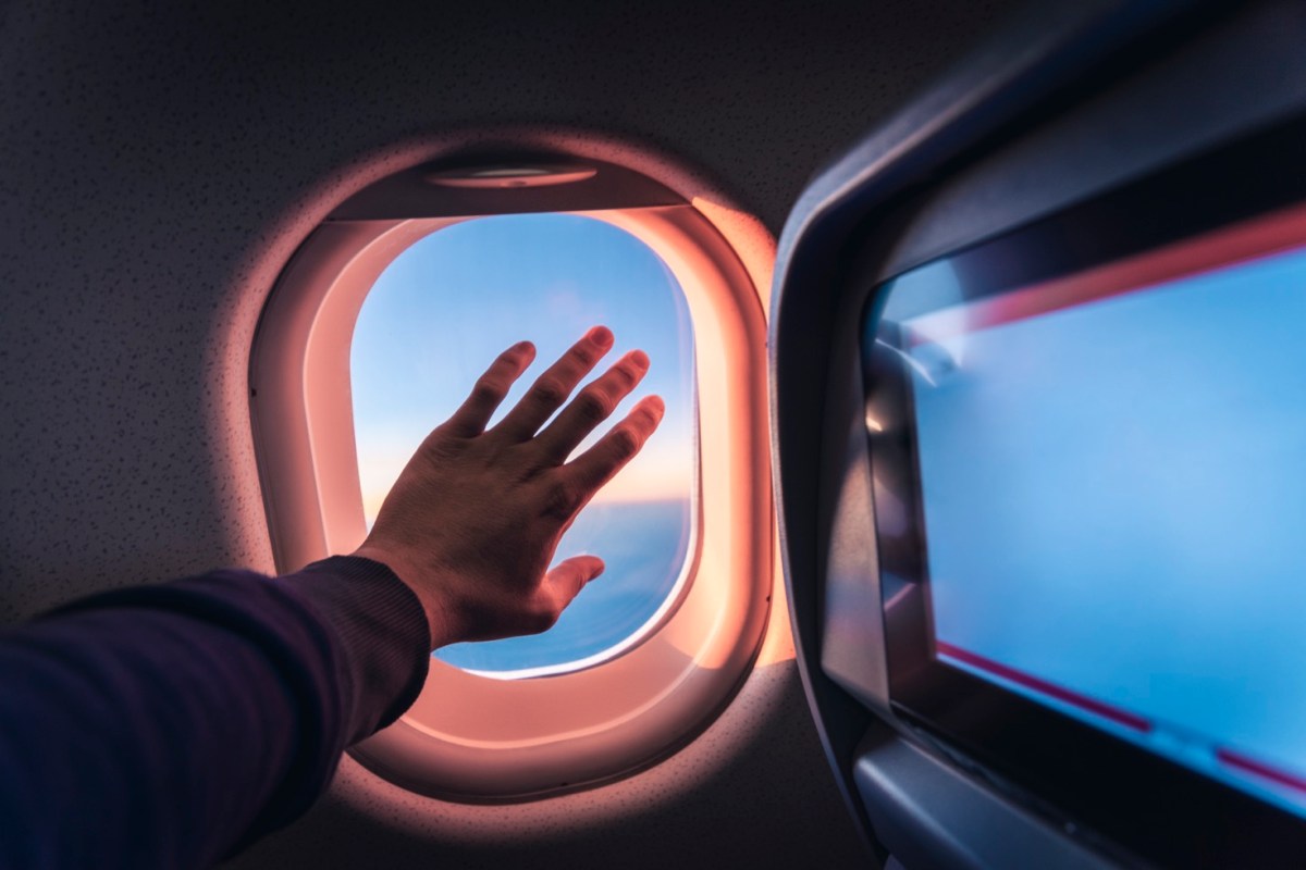 Hand am Flugzeugfenster