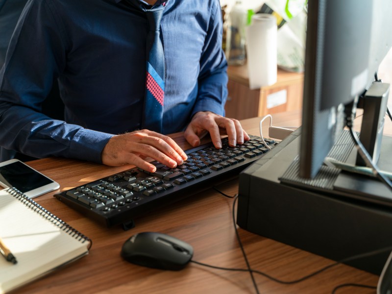 Mann im Anzug sitzt am Computer