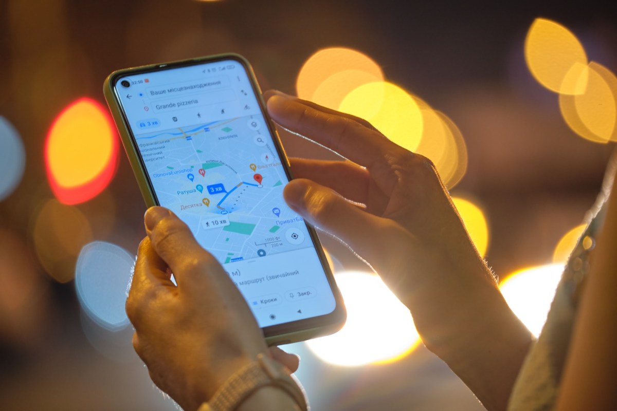 Frau hält Handy mit Google Maps