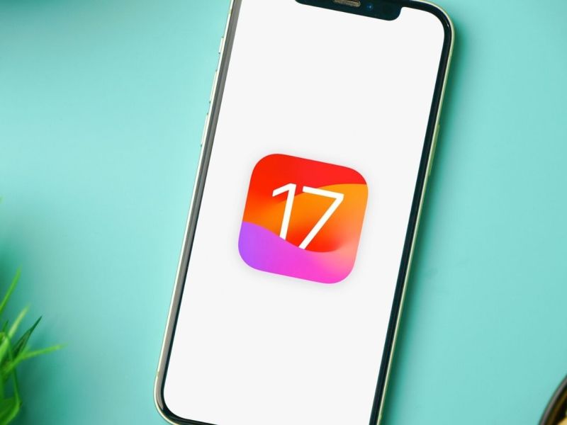 Handy mit einem symbolischen Logo für iOS 17 auf dem Display.