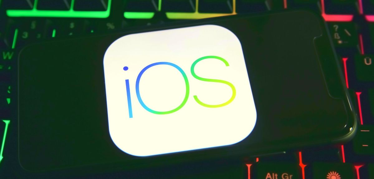Handy mit iOS-Logo auf dem Display.