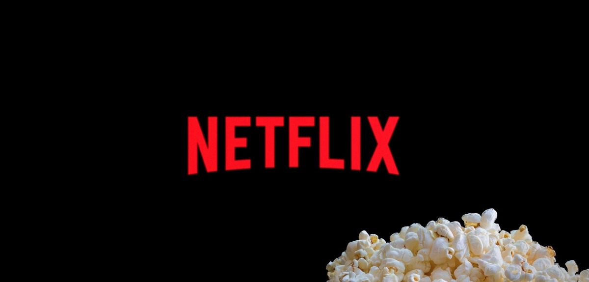 Netflix-Logo auf einem TV, davor Popcorn.