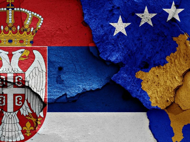 Die Flaggen Serbiens und des Kosovos auf einer rissigen Wand