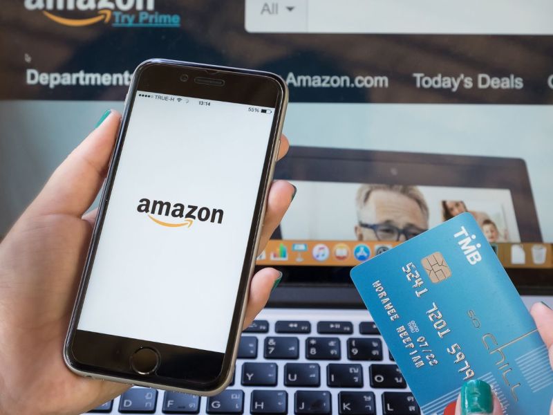 Amazon Logo auf dem Handy daneben die Kreditkarte