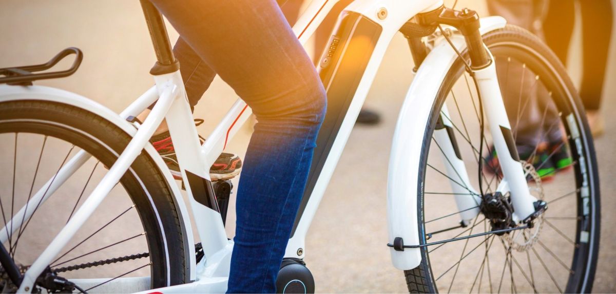 Person sitzt auf einem E-Bike