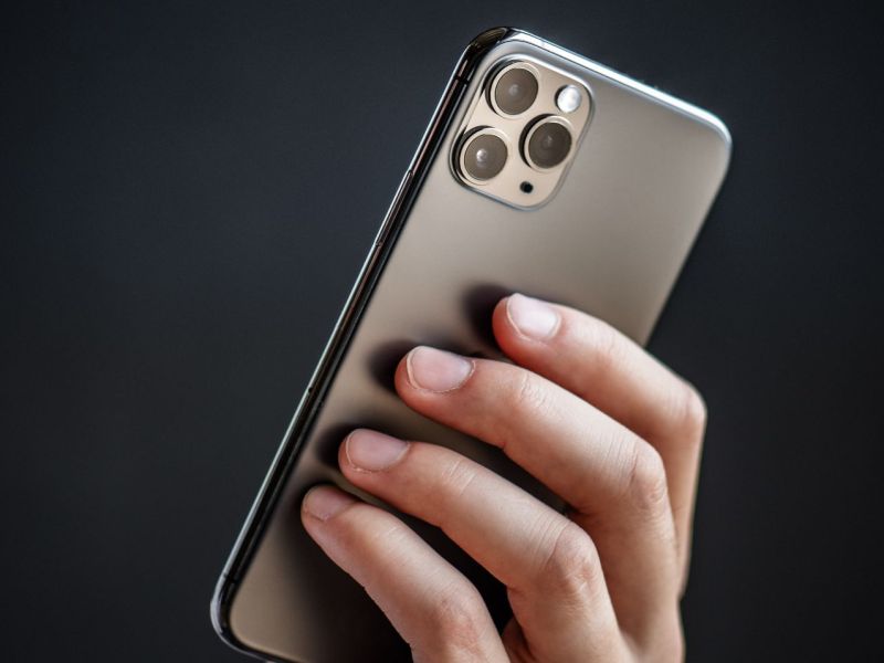 Person hält ein iPhone 11 Pro in der Hand.