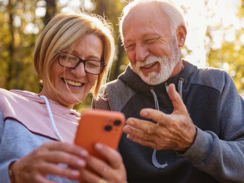 Zwei mittelalte Menschen schauen aufs Handy