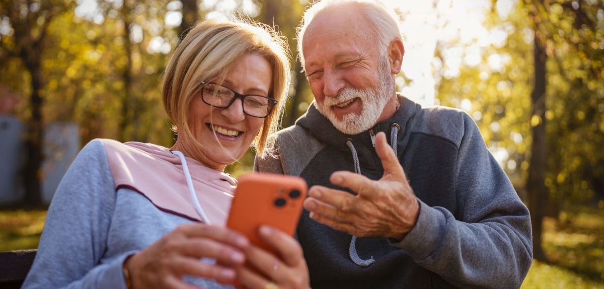 Zwei mittelalte Menschen schauen aufs Handy