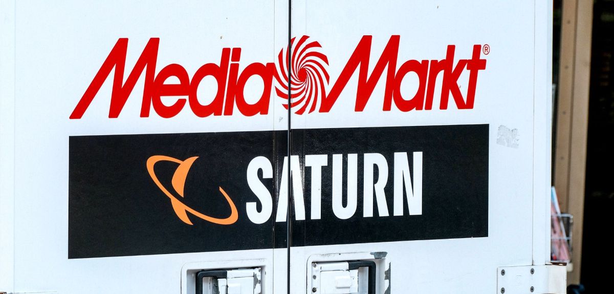 Logos für Media Markt und Saturn auf einem Lastwagen.