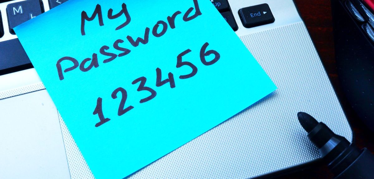 Notizzettel mit einem generischen Passwort auf einem Laptop.