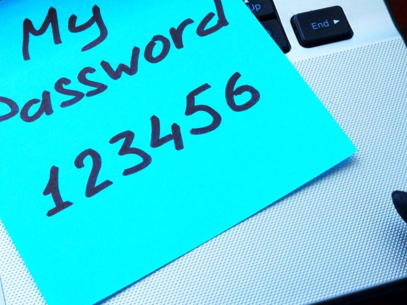 Notizzettel mit einem generischen Passwort auf einem Laptop.