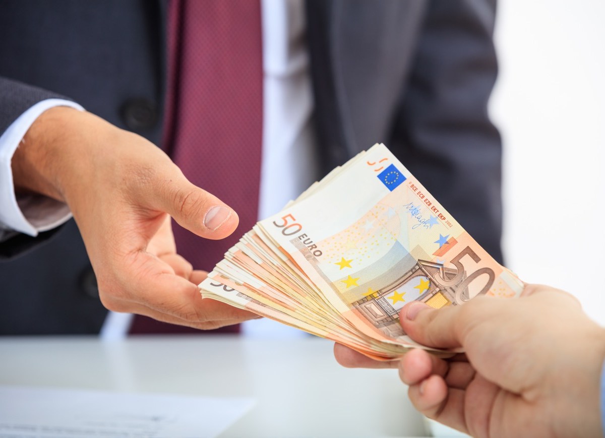 Mann überreicht anderem Mann Euroscheine