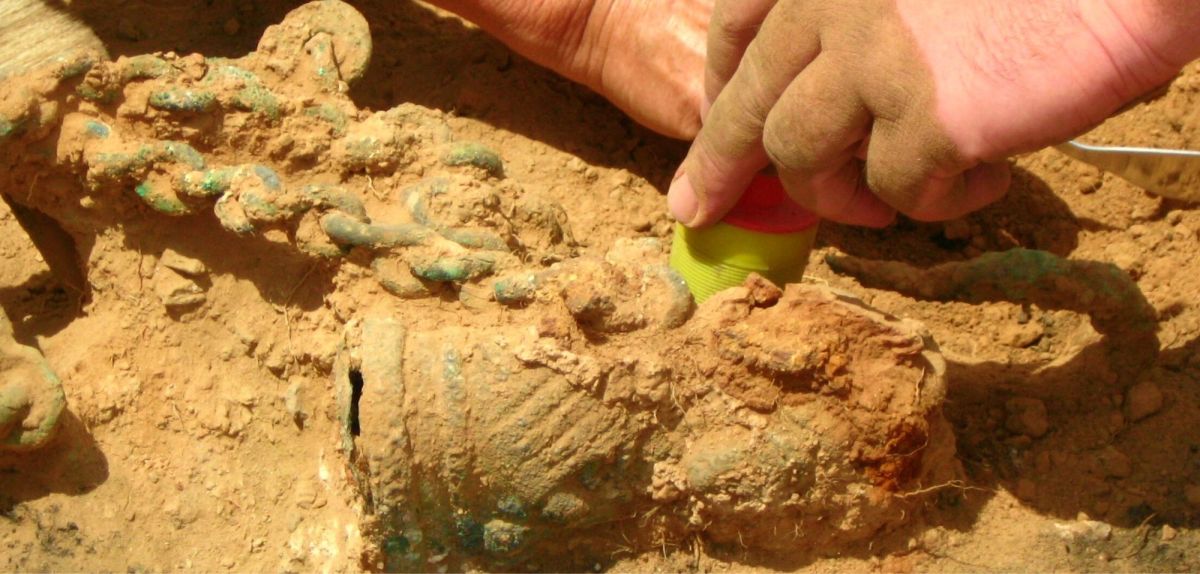 Archäologen graben etwas im Sand aus.