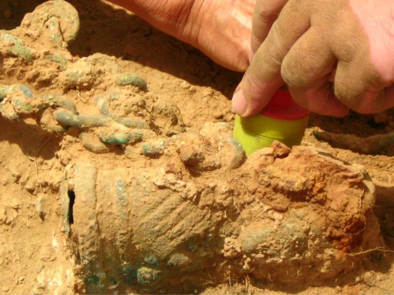 Archäologen graben etwas im Sand aus.