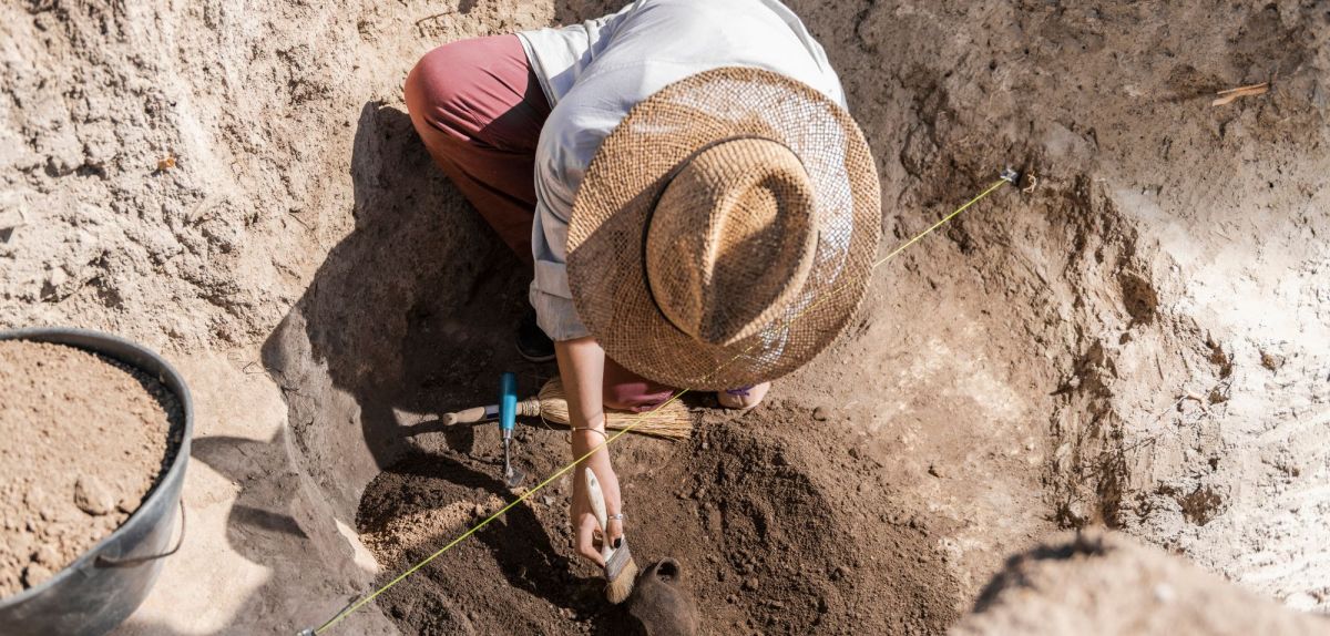 Person bei einer archäologischen Ausgrabung.