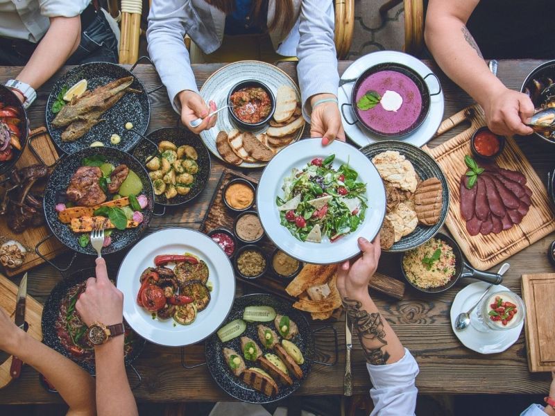 Personen essen gemeinsam am Tisch.