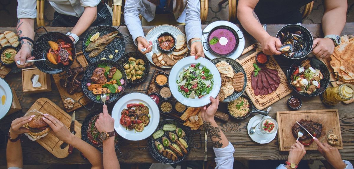 Personen essen gemeinsam am Tisch.