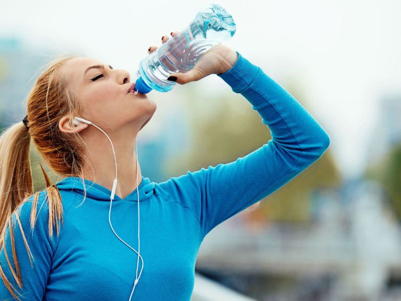 Frau trinkt Mineralwasser aus der Flasche