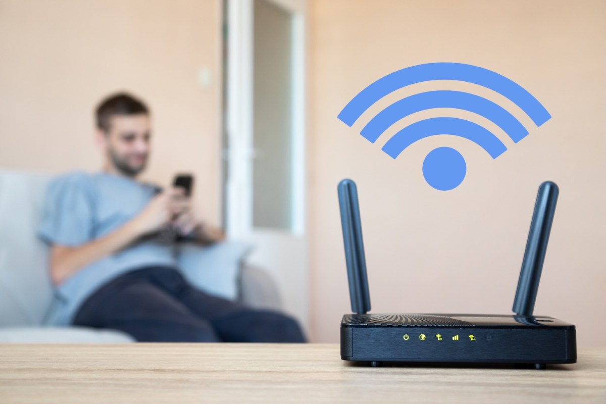 Mann sitzt auf dem Sofa nahe einem Router