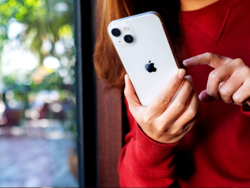 Frau hält weißes iPhone in der Hand