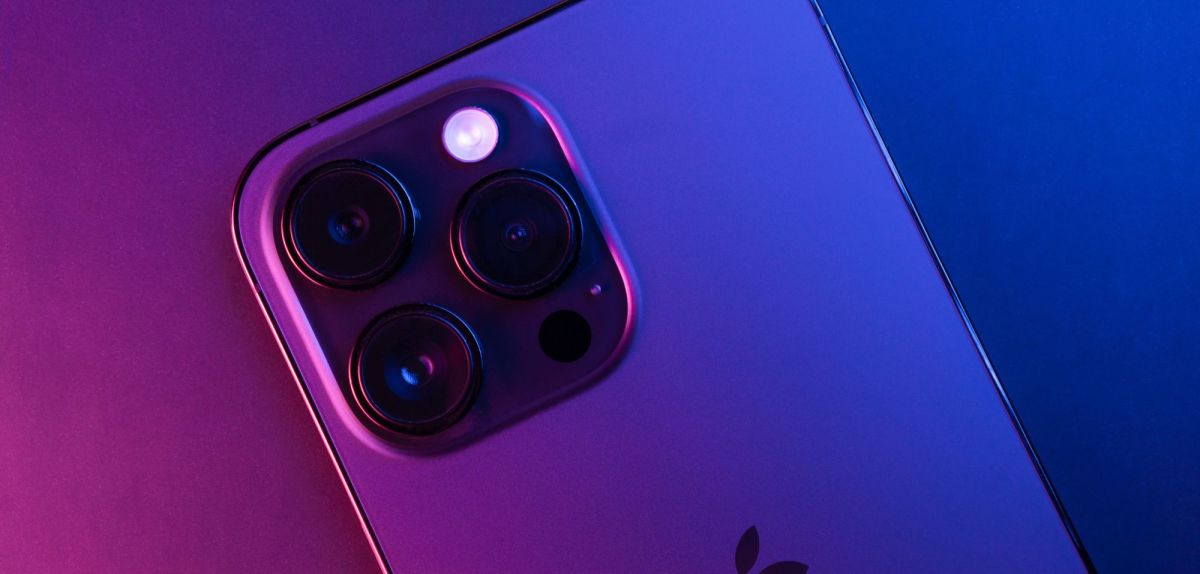 Ein iPhone 14 Pro Max vor lila-blauem Hintergrund.
