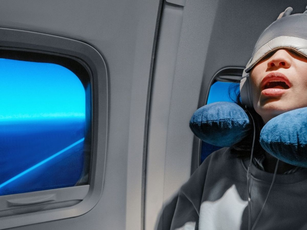 Frau sitzt im Flugzeug und schläft.