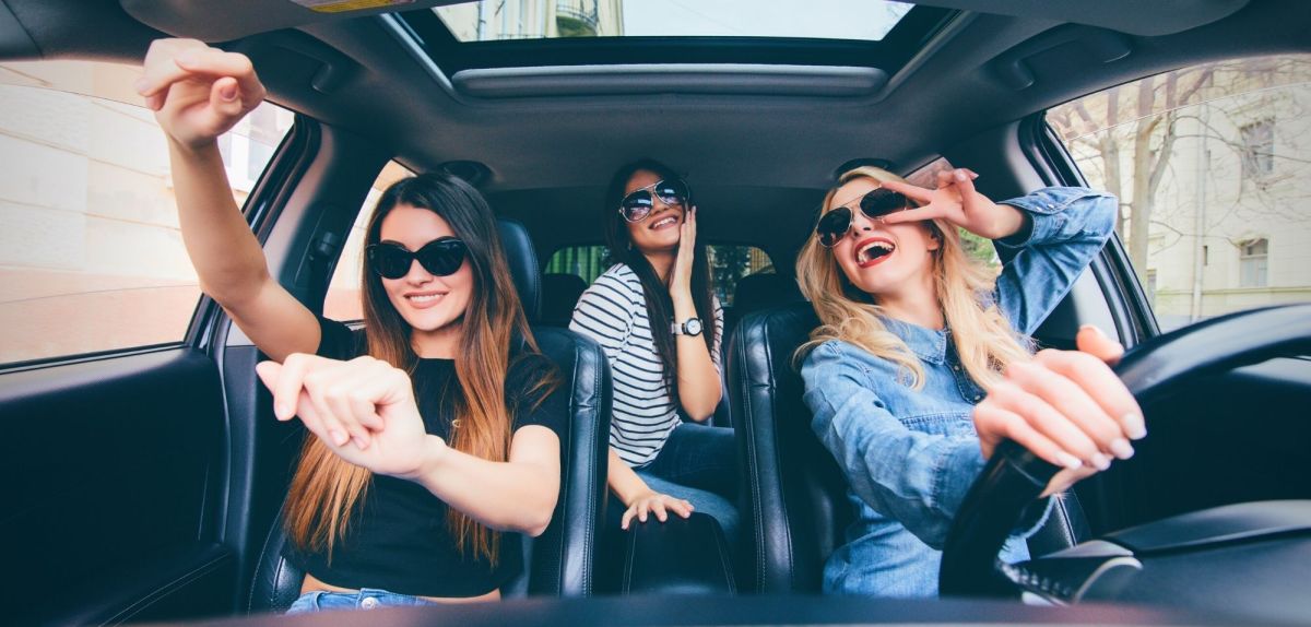 Frauen einem Auto hören Musik und haben Spaß.