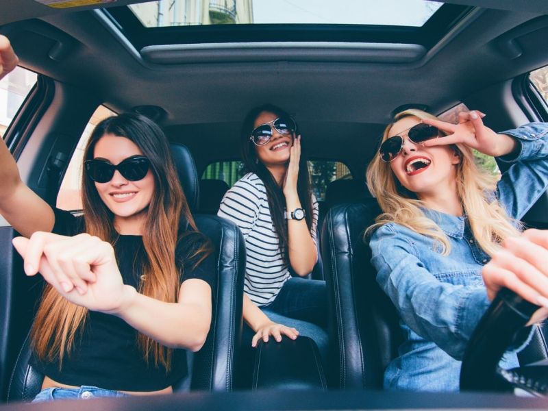 Frauen einem Auto hören Musik und haben Spaß.