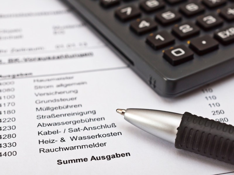 Nebenkostenabrechnung mit Stift und Taschenrechner