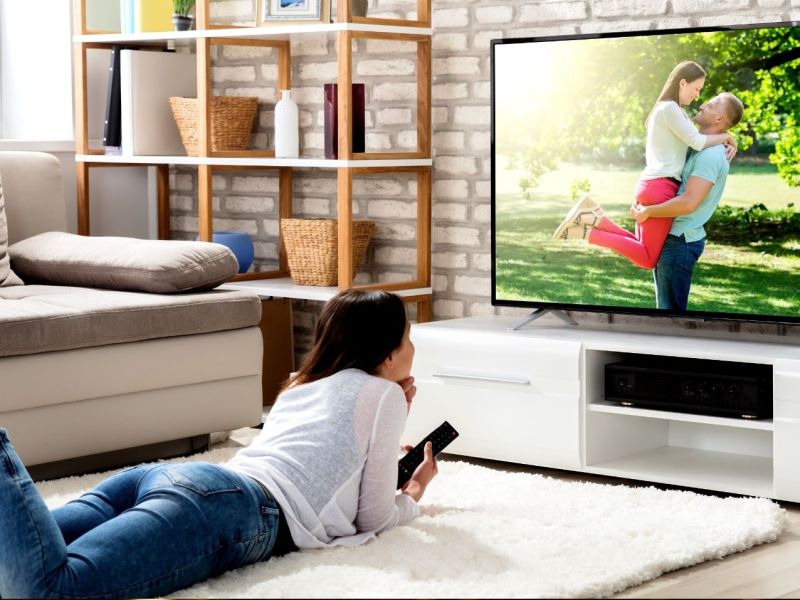 Frau schaut Fernseher im Wohnzimmer.